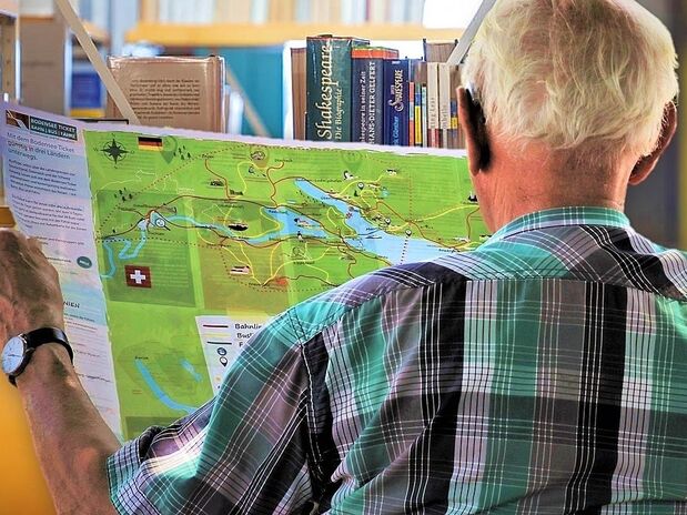 Foto mit einem älteren Leser, der eine Karte vom Bodensee studiert